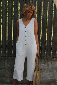 White Cotton Jumpsuits And Rompers For Beach, White Cotton Beach Jumpsuits And Rompers, Summer Relaxed Fit Jumpsuits And Rompers With Bib Front, White Sleeveless Overalls For Spring, Summer White Jumpsuits And Rompers With Pockets, Summer Cotton Jumpsuit With Relaxed Fit, Casual Cotton Overalls With Buttons, Sleeveless Cotton Summer Overalls, Cotton Summer Overalls