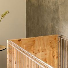 a vase filled with flowers sitting on top of a wooden table next to a metal railing