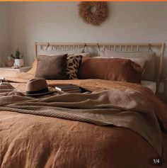 a bed with brown sheets and pillows in a bedroom