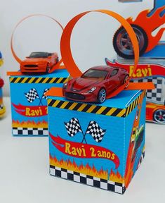 a red toy car sitting on top of a blue box with flames around the edges