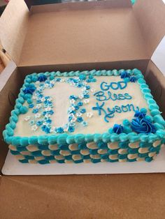 a cake in a box with blue frosting and flowers on the side that says god, blues x'mash