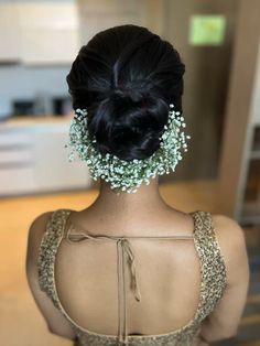 the back of a woman's head with baby's breath in her hair