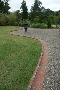 a brick path in the middle of a grassy area