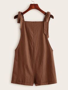 This Pocket Patched Pinafore Romper is the perfect addition to any wardrobe! This stylish romper features two front pockets, knot detailing, and adjustable straps for a custom fit. It's made from cotton fabric in a classic plain pattern that will look great paired with any outfit. The comfortable regular fit allows for plenty of movement while still looking chic and fashionable. Whether you're heading out to the park or just lounging around at home, this pocket-patched pinafore romper is sure to Cotton Overalls With Tie Straps, Casual Cotton Sleeveless Shortalls, Sleeveless Cotton Shortalls, Casual Style, Summer Shortalls With Pockets In Relaxed Fit, Relaxed Fit Summer Shortalls With Pockets, Summer Style Relaxed Fit Shortalls With Pockets, Summer Relaxed Fit Shortalls With Pockets, Sleeveless Summer Shortalls With Pockets, Chic Solid Overalls With Pockets