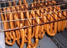 several rows of hotdogs are being cooked in an oven with metal racks holding them