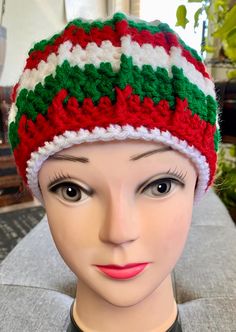 a mannequin head wearing a red, white and green knitted hat