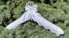 a white lace garter with a bow on top of some pine needles in the grass