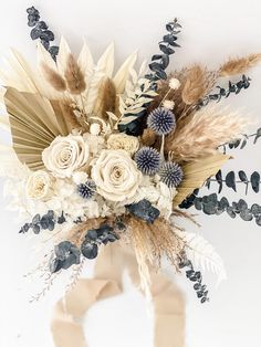 an arrangement of flowers and feathers in a vase