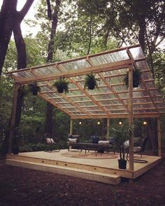 a wooden structure with potted plants on it in the middle of a wooded area