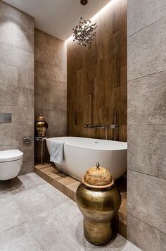 a bathroom with a bathtub, toilet and chandelier in the middle of it