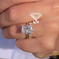 a close up of a person's hand holding a ring with a diamond on it