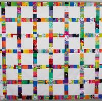 a multicolored quilt hanging on the wall