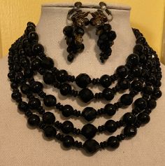 "Up for sale is a 1930's Miriam Haskell 5-Strand Jet Necklace and Earrings made o Grape Vine with Rhinestone and Brass Flowers. Each piece is signed the signature Miriam Haskell Stamp. The set is a Marriage. I acquired them back in the 80's, during the height of collecting Vintage Designer Jewelry. The Necklace has 5-Graduated Strands of Black Jets that are graduated in size as well. The back of the necklace has a brass flower on each end with the Hook and Chain Clasp. The necklace is signed \"Miriam Haskell\" on the back of right brass flower. The earrings are the quintessential Grape Vine Earrings. They too are Black Faceted Jet Glass with 3-Brass and Rhinestone Flowers on each earring. They are the Screw-Spring Back Clip on Earrings. Each Earring is signed on the back of her signature F Faceted Round Jewelry For Evening, Art Deco Faceted Jewelry For Wedding, Art Deco Evening Jewelry With Jewels, Vintage Polished Beads Jewelry For Wedding, Vintage Formal Jewelry With Round Beads, Vintage Jeweled Earrings For Evening, Vintage Jewel Earrings For Evening, Victorian Style Jewelry With Round Beads For Formal Occasions, Art Deco Faceted Jewelry For Formal Occasions