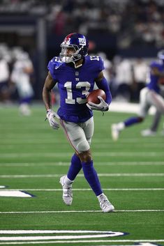 a football player running with the ball in his hand during a game against the giants