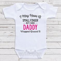 "Cute One-Piece Bodysuits For Babies - I May Have A Small Finger But I Have Daddy Wrapped Around It - Bodysuits for Girls. Great For Baby Shower Gifts, Newborn Clothing, Baby Clothes or 1st birthdays. Short And Long Sleeve Bodysuits Available. Each of our cute bodysuits for babies are professionally heat pressed using a high-quality transfer (NOT iron-on like some vendors use) and the design is embedded in the shirt so that it is machine washable and dryer friendly. It's advised to launder insid Fitted Onesie For First Birthday, Funny Fitted Onesie For Gift, Funny Fitted Onesie As Gift, Cute Pink Onesie For Mother's Day, Funny Fitted Onesie For Gender Reveal, Fitted Funny Onesie For Gender Reveal, Pink Letter Print Onesie For Gender Reveal, Fitted Onesie With Letter Print For First Birthday, Fitted Letter Print Onesie For First Birthday