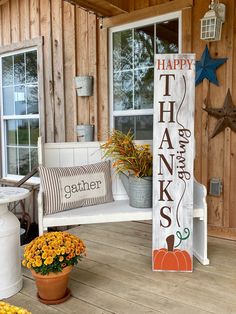 a wooden sign that says happy thanksgiving on the front porch with flowers and pumpkins