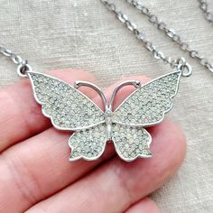 Cute vintage clear rhinestone pave butterfly silvertone pendant necklace. The butterfly has its wings open and the rhinestones are clear with some of them showing color change from age. To me the color variation adds character and gives the necklace a charming vintage vibe. It has nice shine and subtle sparkle. I love the older jewelry it has personally. the necklace is approximately 17" and the butterfly is 1" tall and 2" wide. Silver Butterfly Shaped Jewelry With Rhinestones, Silver Butterfly Jewelry With Rhinestones, Silver Cubic Zirconia Butterfly Pendant Necklace, Silver Butterfly Pendant Necklace In Cubic Zirconia, Silver Butterfly Pendant Necklace With Cubic Zirconia, Vintage Silver Necklace With Butterfly Charm, Crystal Butterfly Charm Necklace, Silver Cubic Zirconia Butterfly Necklace, Vintage Silver Jewelry With Butterfly Charm