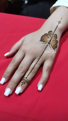 a woman's hand with hennap and cross tattoos on her left arm