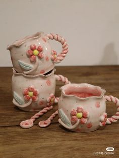 two ceramic teapots sitting on top of a wooden table next to each other