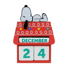 a wooden calendar with a snoopy dog laying on it's side and the date is 24