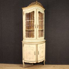 an old white china cabinet with glass doors