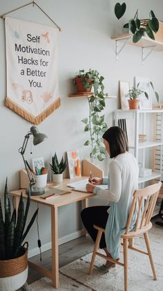 a woman sitting at a desk in front of a wall hanging with motivational hacks for a better you