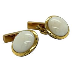 These cufflinks are a stunning piece of jewelry that exudes elegance and sophistication. The cufflinks are crafted from 18k yellow gold, a high-quality material that is known for its durability, luster, and rich color. The gold is carefully crafted to create a sleek and polished design that is both eye-catching and refined. At the center of each cufflink, you will find a striking piece of white coral. White coral is a unique and rare gemstone that is prized for its exquisite beauty and purity. T Gold Cufflinks, White Coral, Rare Gemstones, Black Enamel, Classic Elegance, Rich Color, Contemporary Style, Cufflinks, Coral