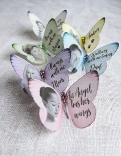 a group of butterflies with pictures on them sitting on top of a white table cloth