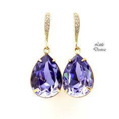 a pair of earrings with purple and white stones on them, set in 18k yellow gold