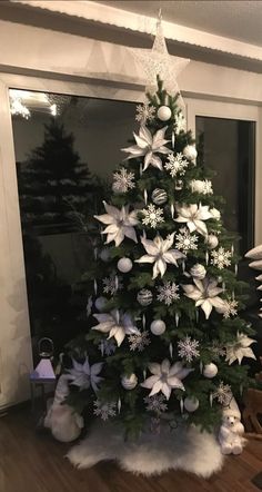 a christmas tree with white and silver decorations