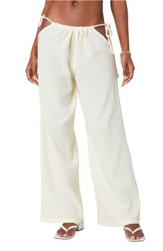 Daring hip cutouts with rope-style ties pay homage to Y2K in vacation-ready pants cut from fresh cotton gauze and boasting a breezy wide-leg fit. Drawstring waist with side ties 100% cotton Machine wash, line dry Imported Beach Straight Pants With Drawstring, Cotton Beach Pants With Tie Waist, Cotton Wide Leg Bottoms For Beach Season, Cotton Wide Leg Pants For Beach Season, Breezy Wide Leg Cotton Bottoms, Wide Leg Cotton Bottoms For Beach Season, Cotton Pants With Tie Waist For Beach, Wide Leg Cotton Pants For Beach Season, Cotton Parachute Pants For Spring Vacation