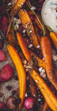 carrots, potatoes and other vegetables are on the ground next to a bowl of yogurt