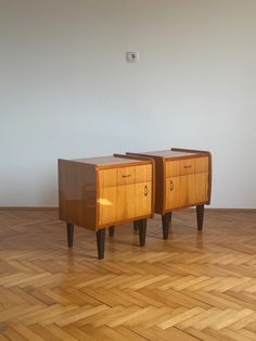 two wooden side tables sitting on top of a hard wood floor next to each other