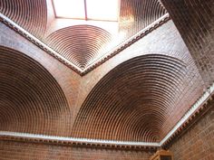 the inside of a brick building with a skylight in the center and several arches on each side