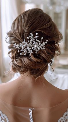 the back of a woman's head wearing a bridal hair comb with pearls