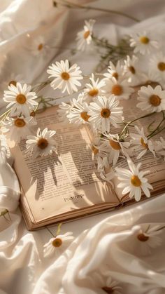 an open book with white daisies on it