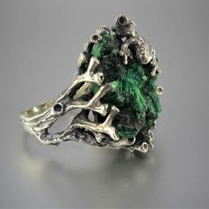 The ring of Melant is made manually of 925 sterling silver and natural plaid malachite. The ring is manually assembled directly on the stone. Each ring is individual and unique. The texture of plisse malachite resembles the interweaving of overgrown branches of a shrub, and the luster of the polished surface is akin to the dull flicker of twisted silk. Such a stone can be used in contrast with turquoise malachite - mainly as a low-expressive background. Malachite is a stone that perfectly combin Nature-inspired Green Jewelry With Raw Stone, Unique Green Jewelry With Raw Stone, Unique Sterling Silver Green Emerald Ring, Green Sterling Silver Nature-inspired Ring, Green Sterling Silver Jewelry With Raw Stone, Unique Hand Cast Green Jewelry, Unique Green Hand Cast Jewelry, Unique Hand-cast Green Jewelry, Handmade Green Emerald Ring, Nature-inspired