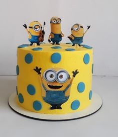 a yellow cake with blue polka dots and minion figures on top