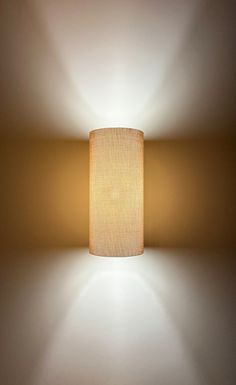 a lamp that is on the wall with a white light in it's corner