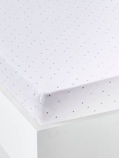 a close up view of the top of a baby crib mattress with polka dots on it