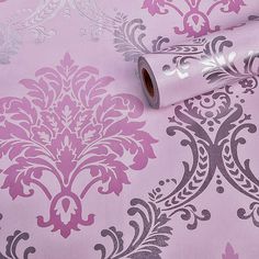 a pink and silver wallpaper with an ornate design on the side, next to a roll of metallic foil