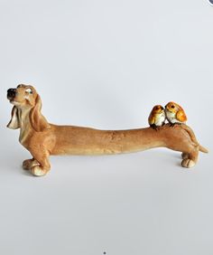 a dog figurine with two birds on its back