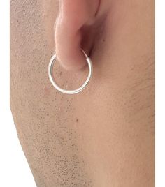 a close up of a person's ear with a silver ring on the side