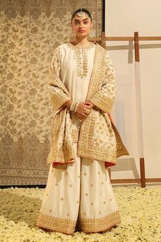 Ivory straight kurta with gota patti, dabka, zardozi embroidery in floral pattern. Paired with a sharara with embroidered buttis and dupatta with floral jaal embroidery. - Aza Fashions Off White Sharara For Festivals With Straight Kurta, Off White Straight Kurta Sharara For Festivals, Off White Sharara With Straight Kurta For Festivals, Off White Palazzo Set With Zari Work For Festivals, Off-white Palazzo Set With Zari Work For Festivals, Traditional White Palazzo Set With Zari Work, Off White Traditional Wear With Gota Work For Eid, Traditional Off White Palazzo Set For Eid, Traditional Off-white Palazzo Set For Eid