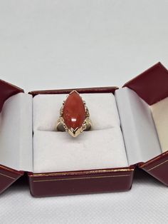 This exquisite ring features a stunning red coral design with a leaf motif on each side, crafted from 14k solid gold. The setting style is designer, making it a unique and fashionable addition to any jewelry collection. The ring is suitable for wear and is perfect for any occasion.  The metal purity is 14k and the color is red, making it a standout piece.  Add this beautiful ring to your collection today and enjoy its beauty for years to come. The total weight of the ring is 6 grams. The ring size is 5 3/4 can size up The ring itself measures approx. 23mm x 14mm wide. The ring marked 14k and ming's inside. The ring is pre owned and in good condition Red Marquise 14k Gold Jewelry, Red 14k Gold Marquise Cut Jewelry, Red Marquise-cut 14k Gold Jewelry, Red Marquise Cut 14k Gold Jewelry, Antique 14k Gold Marquise Ring, Antique Marquise 14k Gold Rings, Red 14k Gold Marquise Ring, Red Marquise 14k Gold Ring, Marquise Ruby Ring In 14k Gold