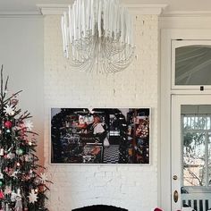 a living room with a christmas tree in the corner and a painting on the wall