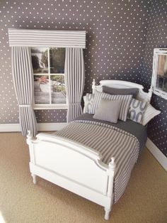 a white bed sitting in a bedroom next to a window with polka dots on it