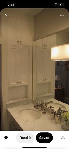 a white bathroom sink sitting under a mirror next to a counter top with two faucets on it