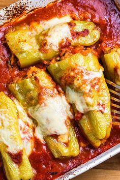 a pan filled with stuffed peppers covered in sauce