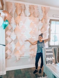 a woman standing in front of a wall with balloons